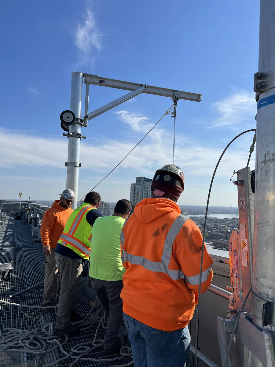 Team members beside a rooftop davit
