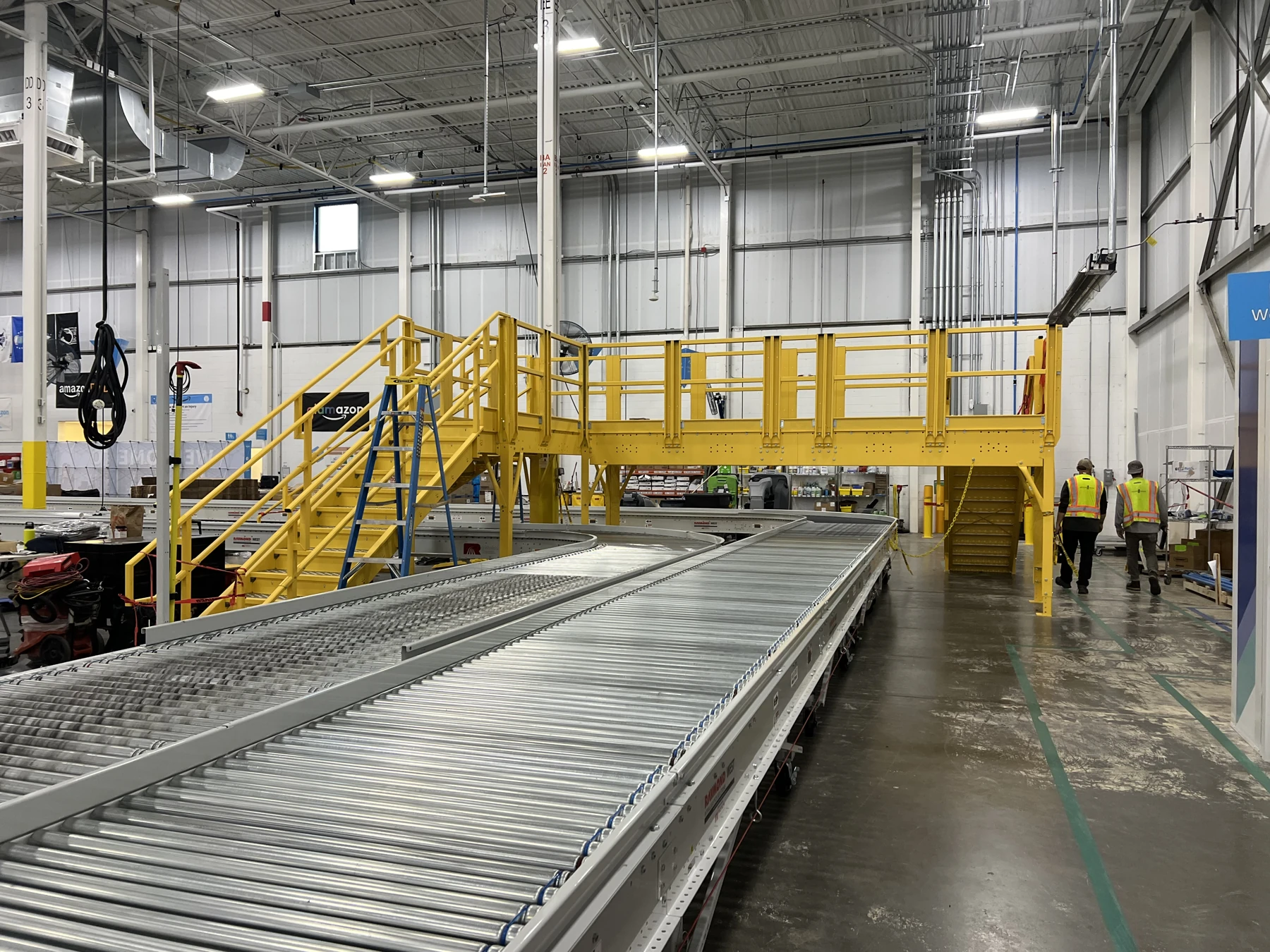 Industrial crossover stairs and platform above conveyor equipment.