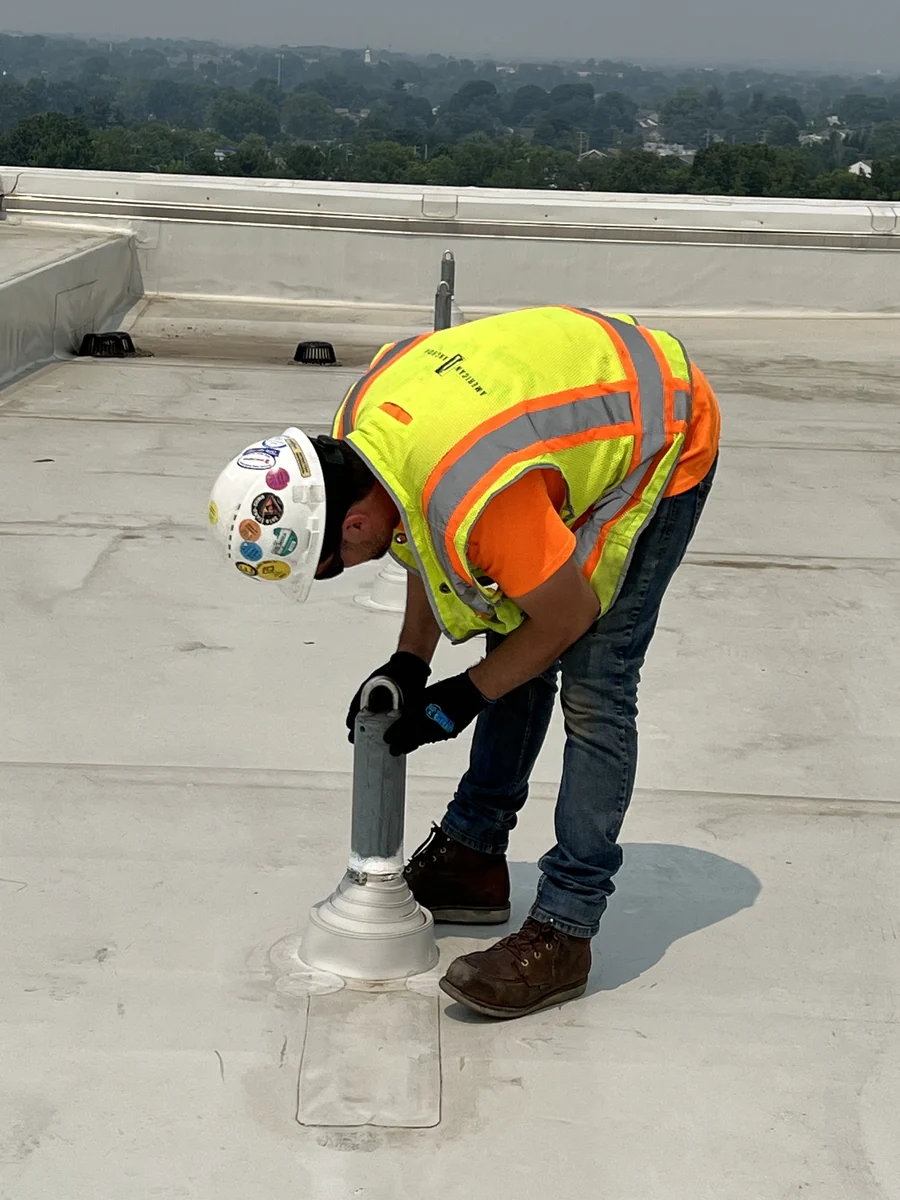 American Anchor worker inspecting an installed roof anchor.