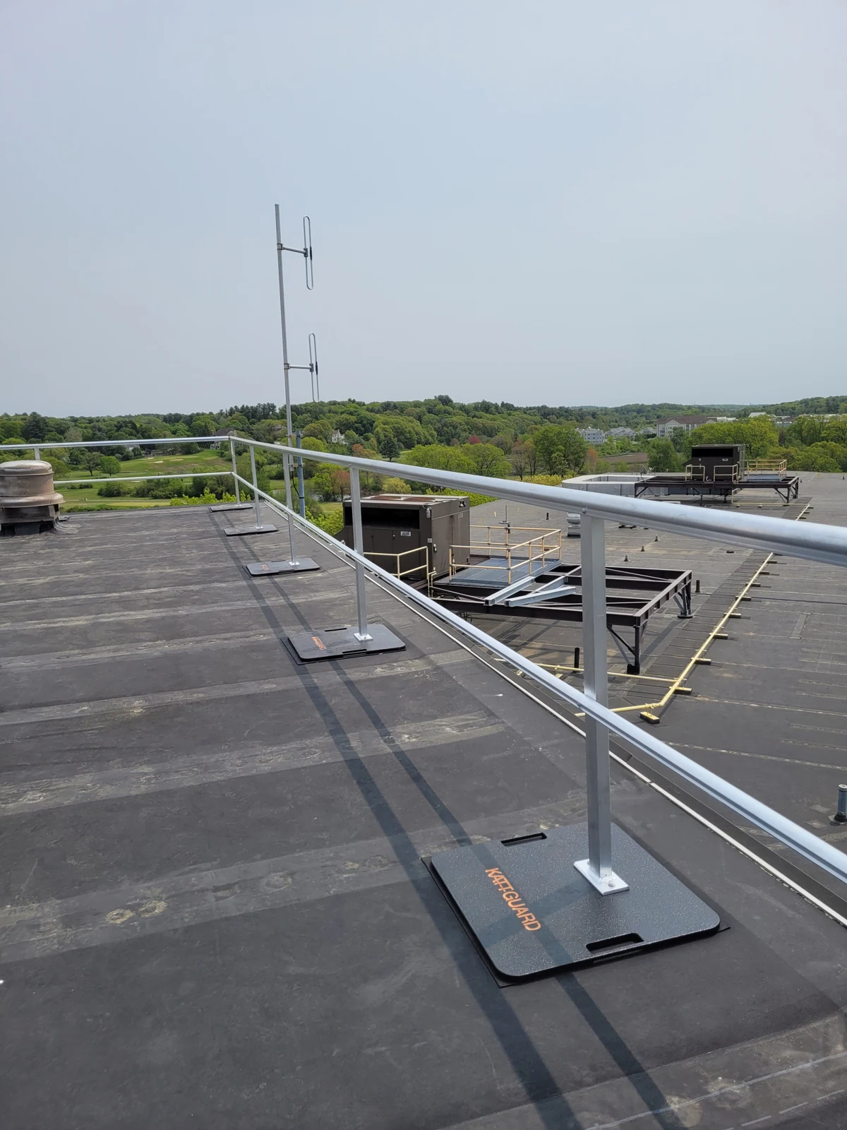 Roof-edge guardrail with weighted bases.