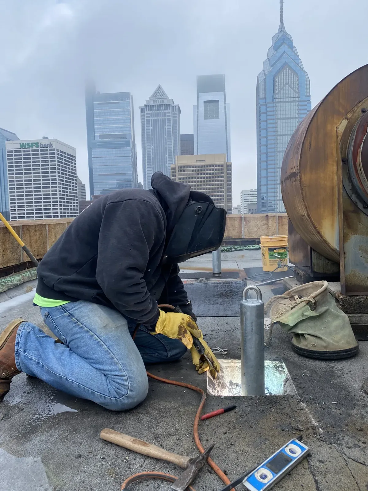 Setting a roof anchor on a downtown rooftop